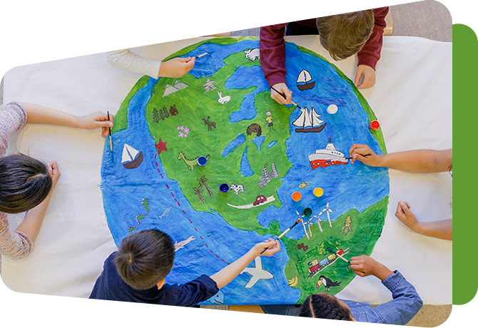 circle of children reaching across a large drawing of a globe