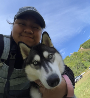 Angie Barrera Gonzalez smiling with her dog, Mochi.