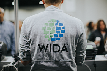 back of person wearing a WIDA logo t-shirt
