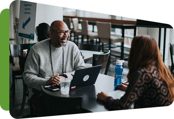 two WIDA employees talking at a table