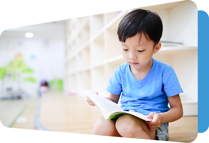 little boy reading a book in a resource room