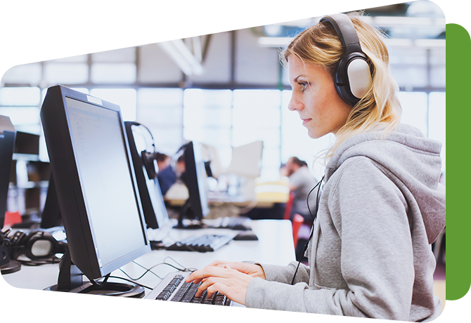 young woman at computer with headphones on