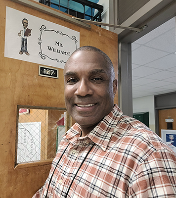 Reggie Williams in front of the door to his classroom