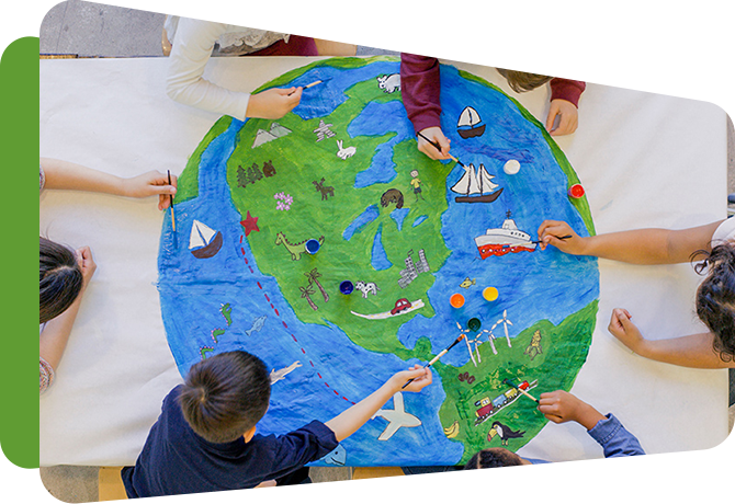 circle of kids reaching into a large drawing of the earth
