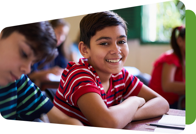 boy at desk in classroom with other students