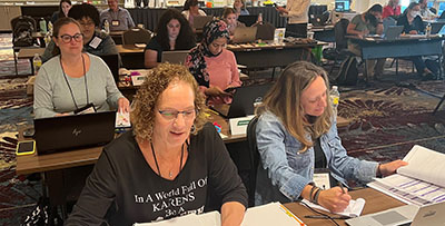 educators working at tables in a large room