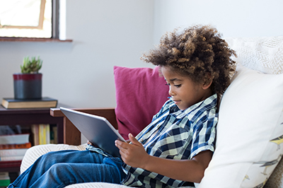 Boy sitting on couch with tablet