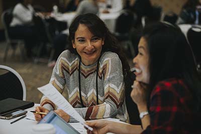 two women talking at conference table