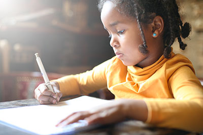 Girl writing on piece of paper