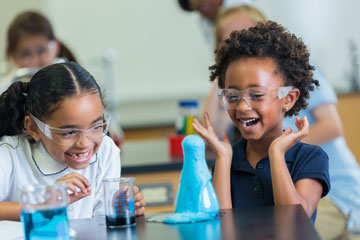 two young students with beakers