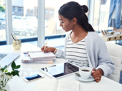 woman at desk working on tablet 