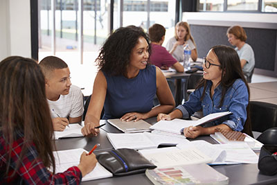 woman at table with children, books and papers on the table