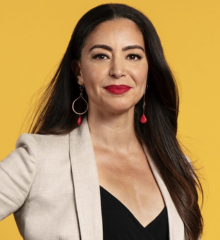 Headshot of Shereen wearing a black shirt and beige coat