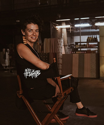 Quiara Alegría Hudes sits in a chair with the words "In the Heights" on it