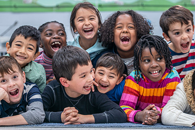 A group of children smile and laugh