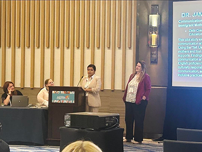 Delis Cuéllar stands at podium to be recognized by AERA.