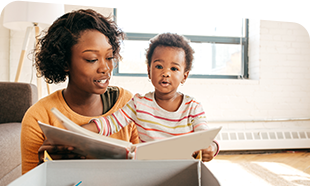 adult and small child looking at a picture book