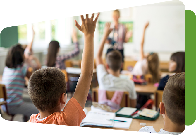 view from back of classroom of student raising hand