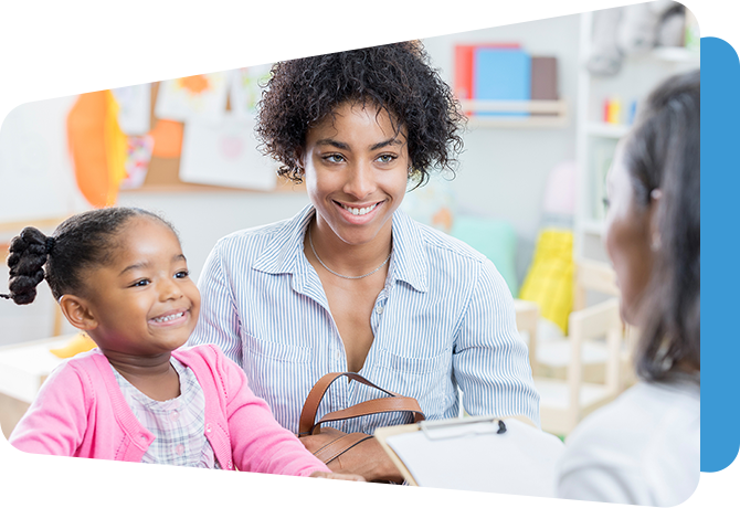 mother with girl listening to teacher at table