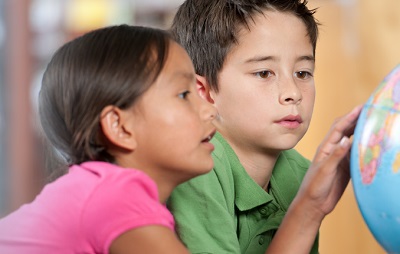 Two students looking at a globe.